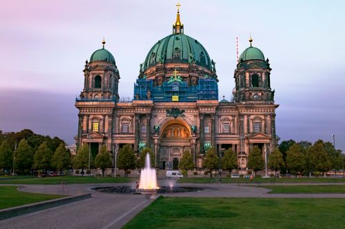 Free Stunning view of Berlin Cathedral illuminated by sunset hues against a serene sky. Stock Photo