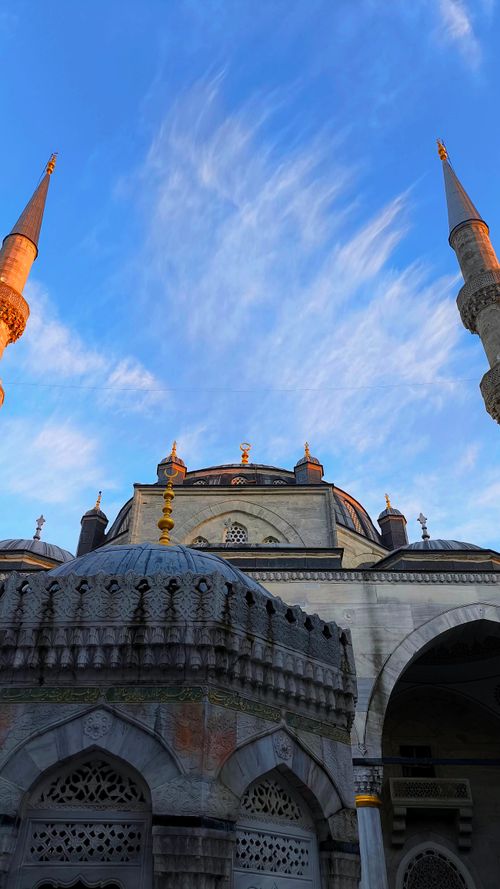 Free Ottoman-style mosque with intricate domes and minarets under a clear blue sky. Stock Photo