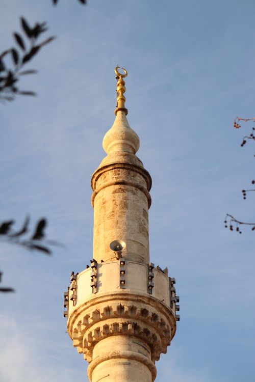 Free Close-up of a beautifully ornate mosque minaret with a clear blue sky background. Stock Photo