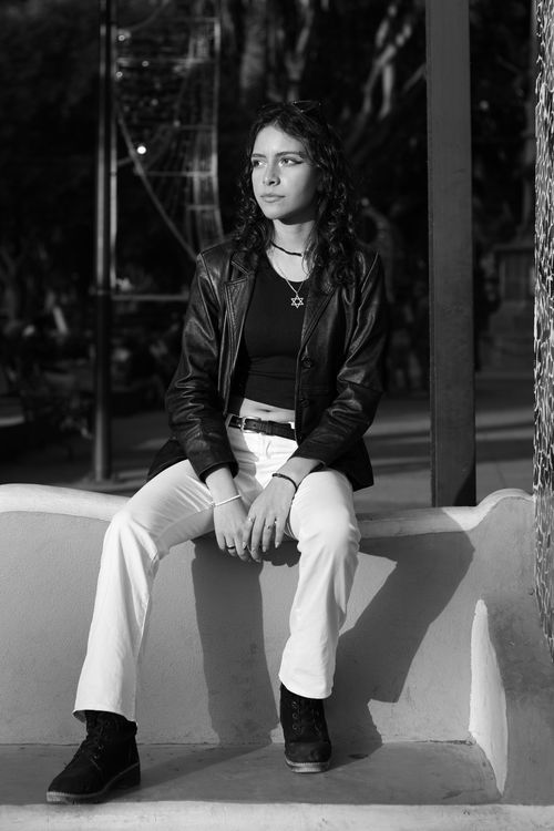 Free Black and white portrait of a stylish young woman sitting outdoors. Stock Photo