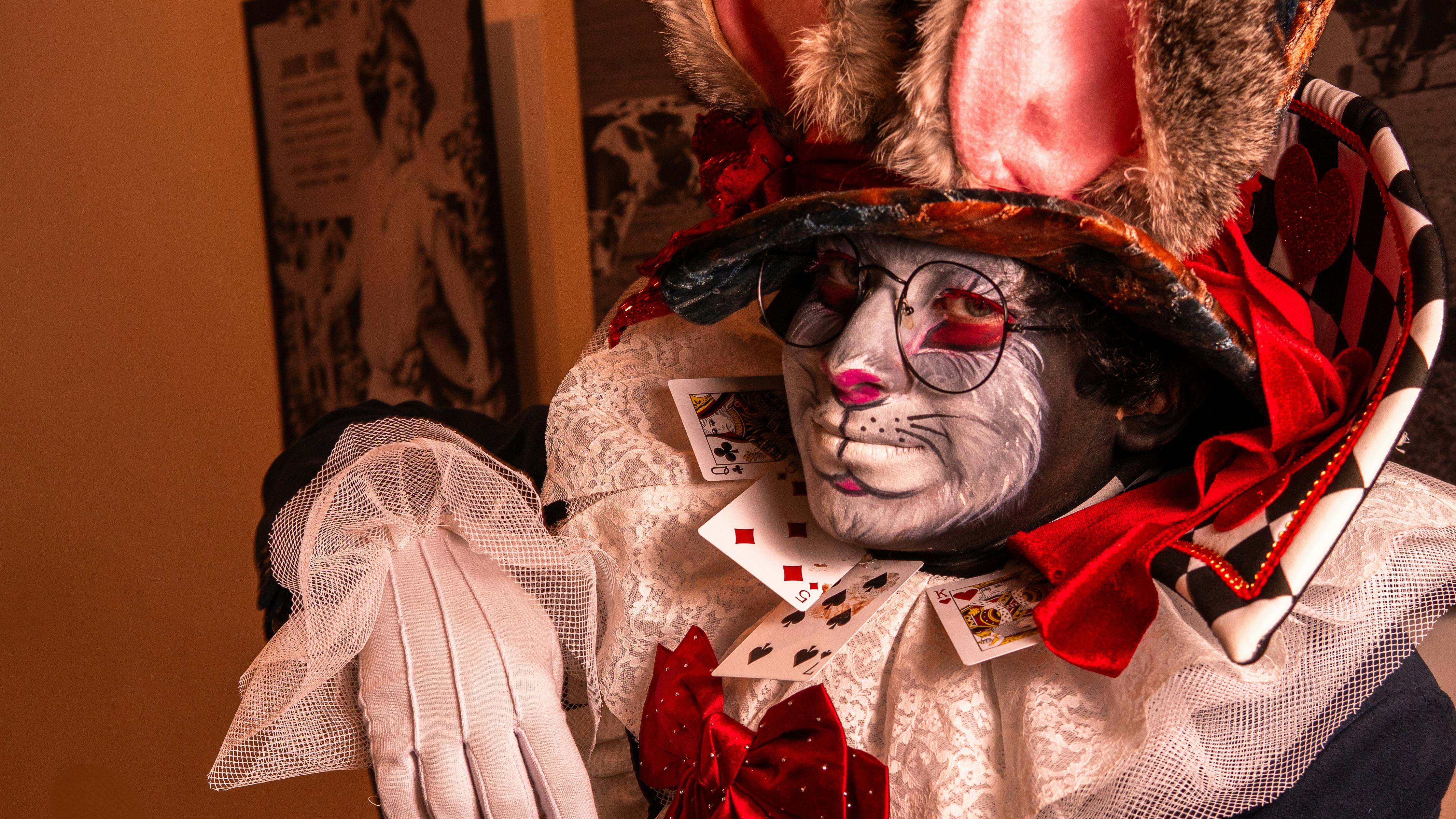 A captivating cosplay featuring a Mad Hatter inspired character with vibrant colors and playing cards.