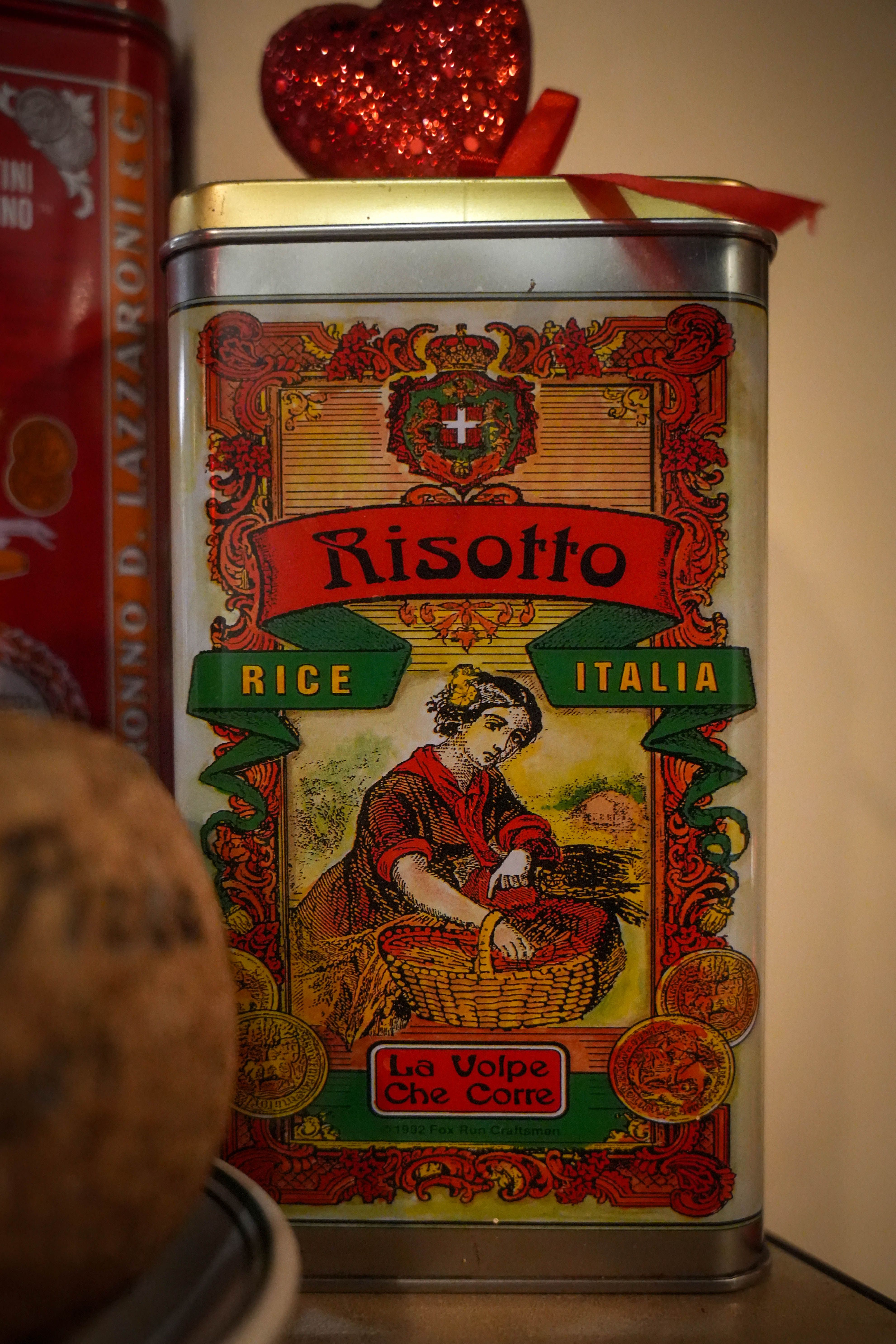 Colorful vintage tin of Italian risotto with a red heart decoration, showcasing classic design.