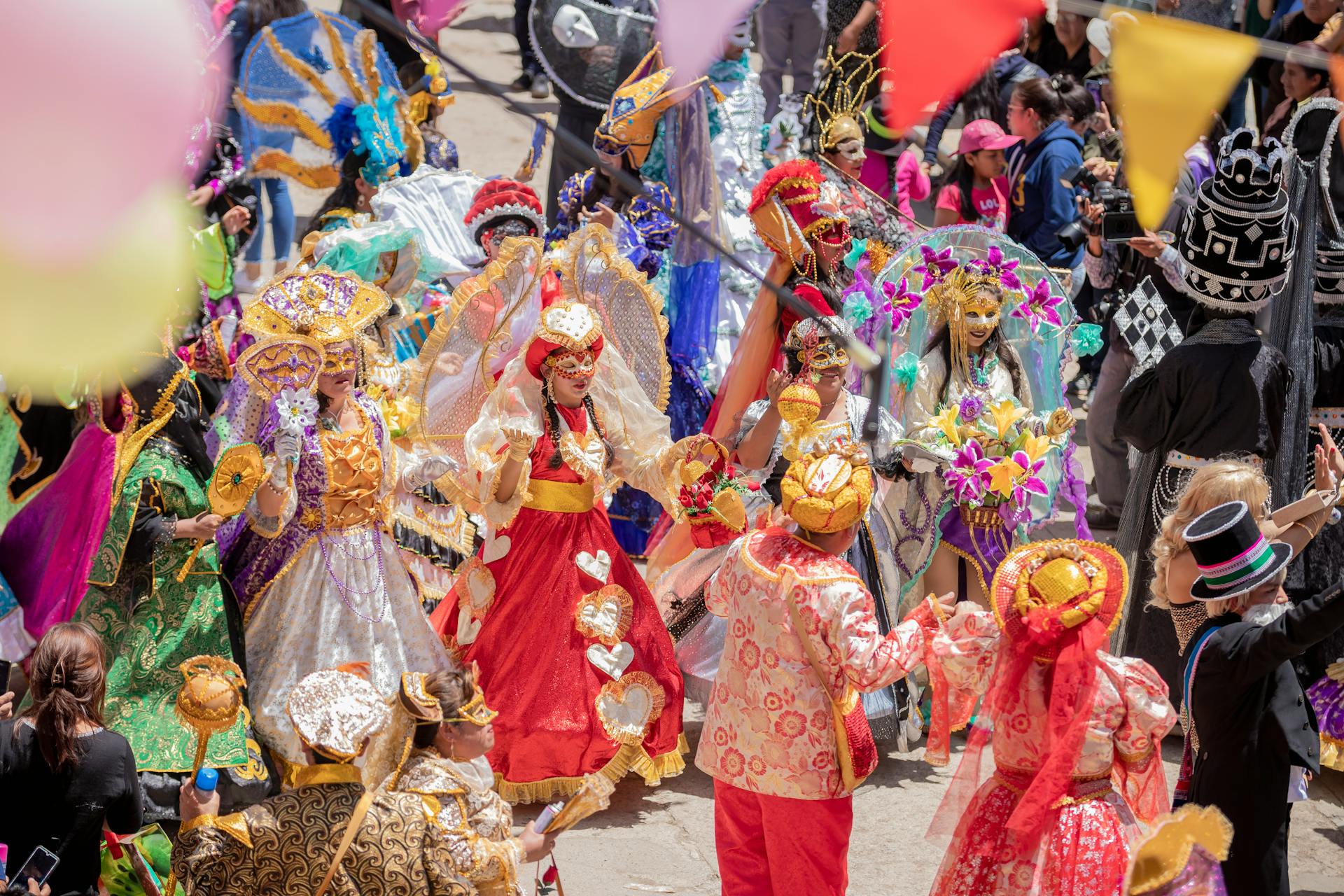 Vibrant carnival parade with participants in ornate costumes and masks, celebrating culture and tradition outdoors.