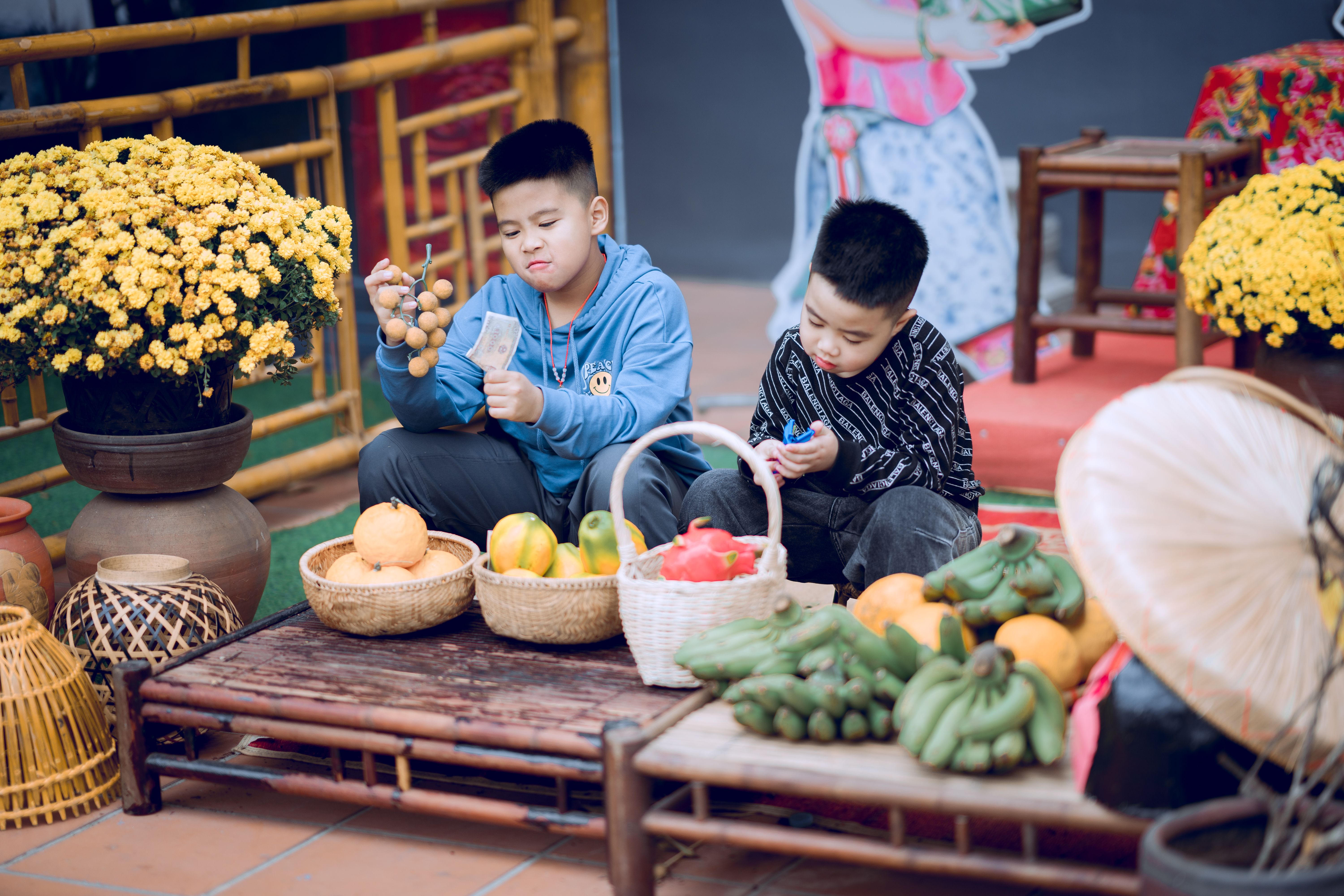 Dua anak sedang mengamati sayur dan bunga di pasar