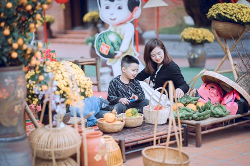 Free Mother and child exploring vibrant Asian market with fresh fruits during festive celebration. Stock Photo
