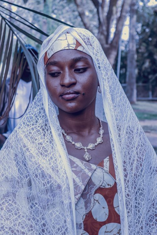 Free Portrait of a woman in traditional attire with a lace veil, outdoors in a serene setting. Stock Photo