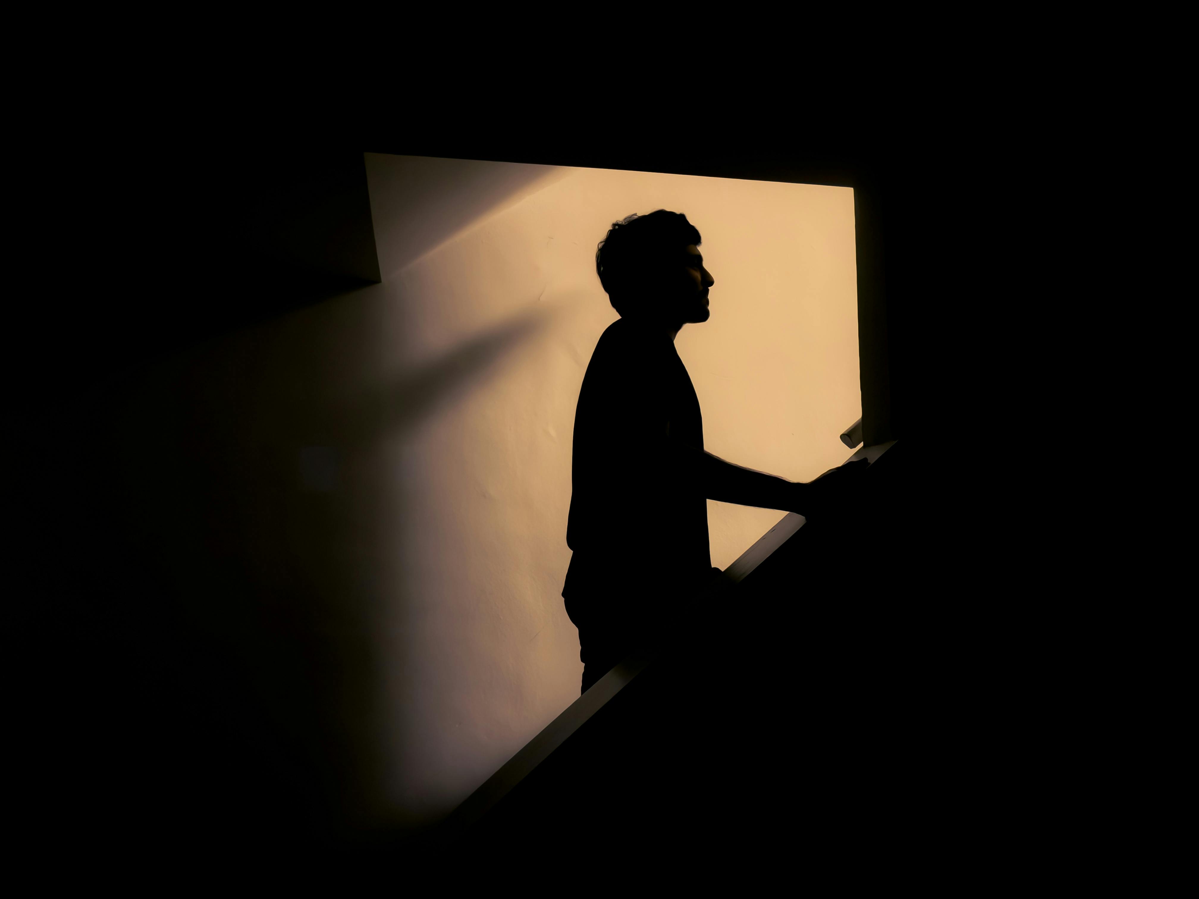 Zadarmo Umelecká silueta muža na schodoch s dramatickým osvetlením. Fotka z fotobanky