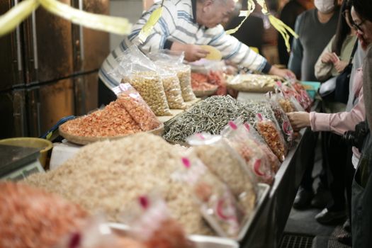 Vibrant market scene showcasing dried seafood and beans at an Asian night market.