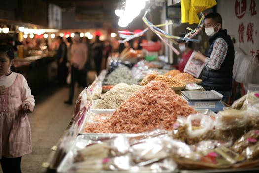 A bustling Asian market scene featuring colorful dried seafood and diverse bustling atmosphere.