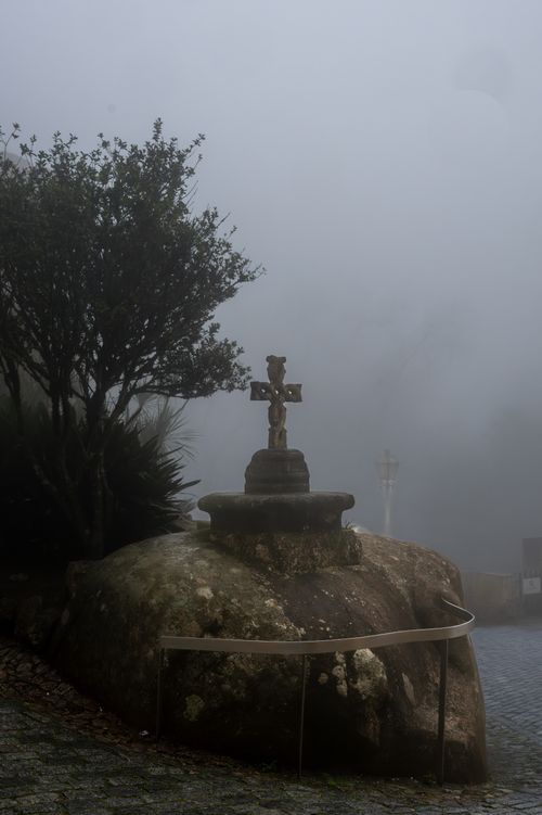 Free A misty scene with a historical cross on a rock in Sintra, Portugal. Stock Photo