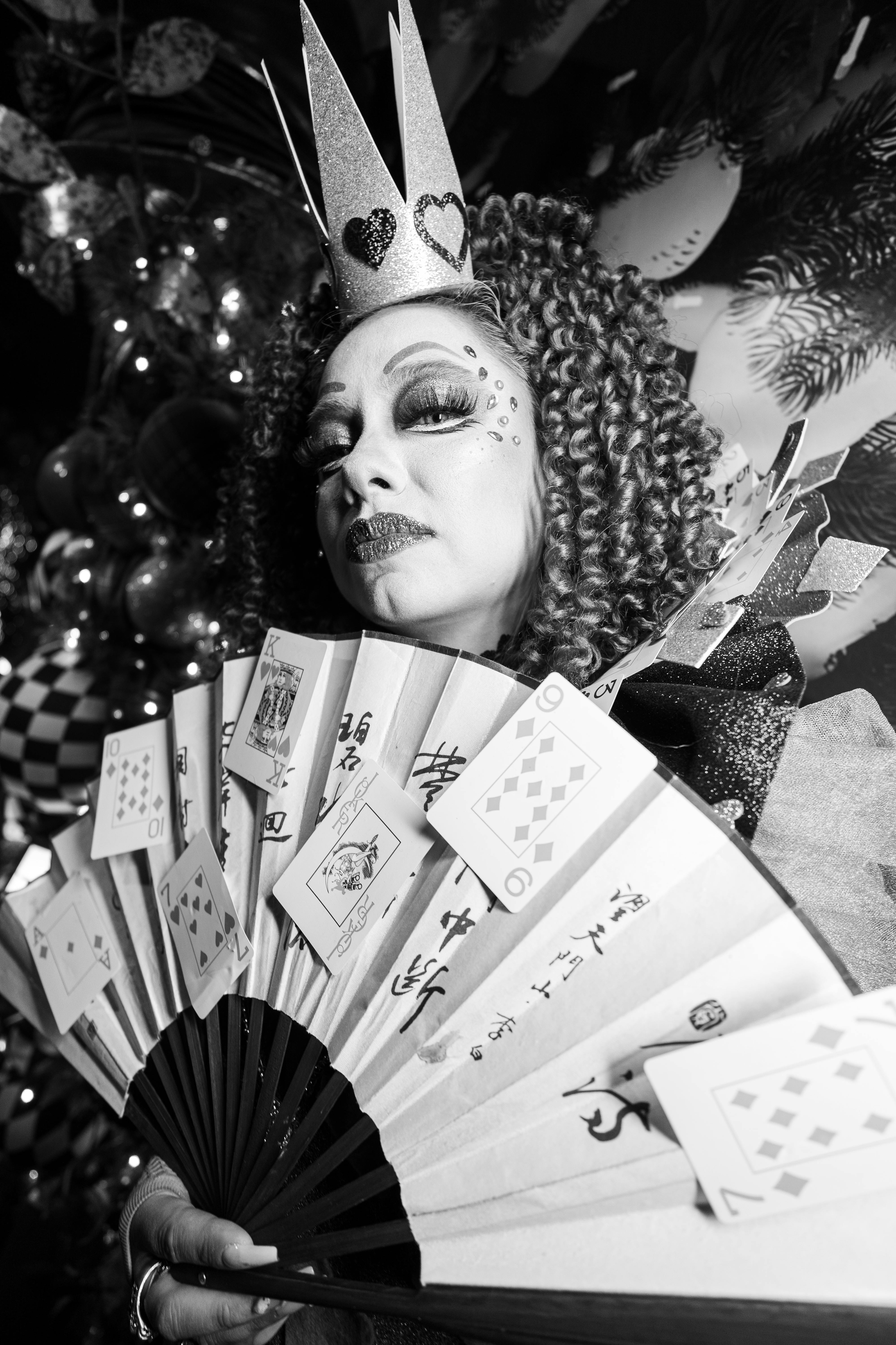 Ücretsiz Sanatsal bir ortamda, elinde oyun kağıtları ve yelpaze tutan taçlı bir kadının siyah beyaz portresi. Stok Fotoğraflar