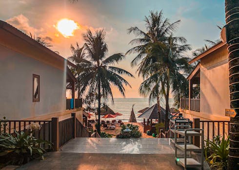 越南富国度假村棕榈成荫的海滩上，美丽的日落营造出宁静的热带氛围