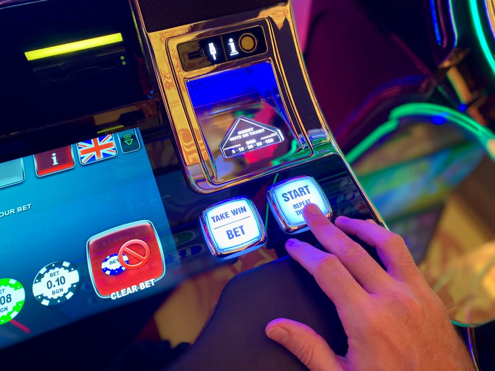Layar dan tombol mesin slot dalam cahaya redup