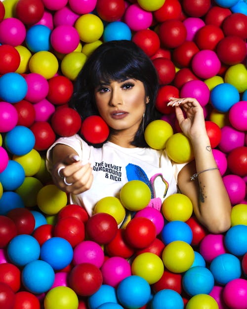 Photo Of Woman Laying On Assorted-Colored Balls