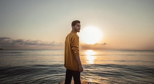 Homme Portant Haut Brun Debout Sur Le Bord De Mer