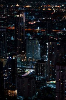 Stunning night view of Bangkok's illuminated cityscape with towering skyscrapers and vibrant lights.