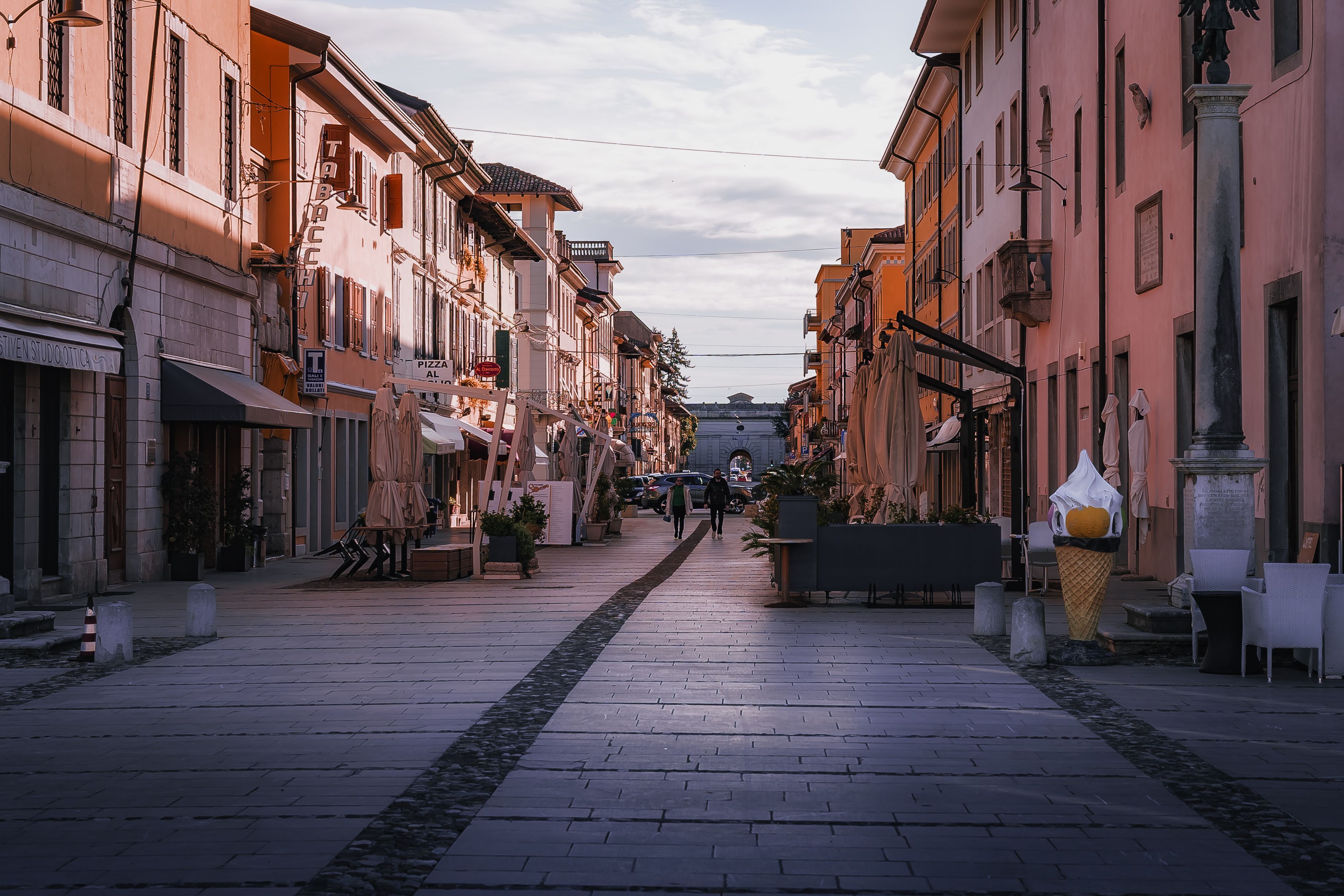 A picturesque European street scene at dusk with warm lighting and quiet atmosphere.