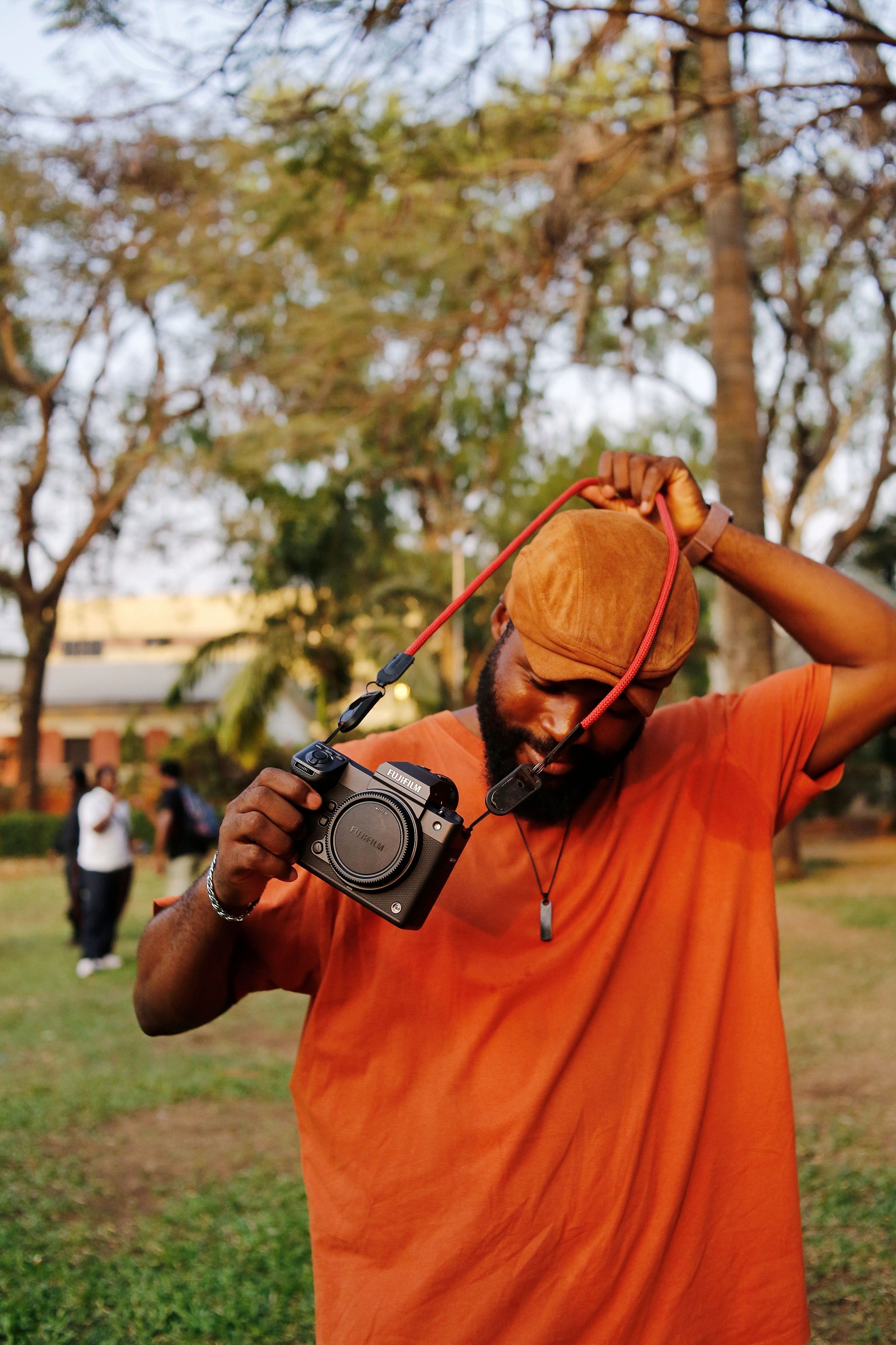 Photographer in an orange shirt adjusting his camera in Abuja