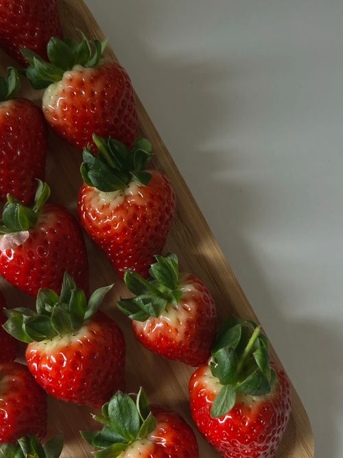 Free Top view of ripe strawberries on a wooden board, ideal for fresh food themes. Stock Photo