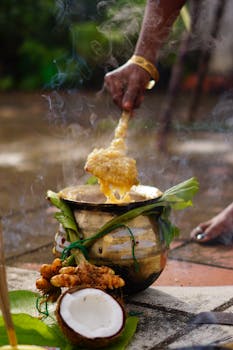 Hand stirring Pongal in a traditional pot during South Indian festival celebration.