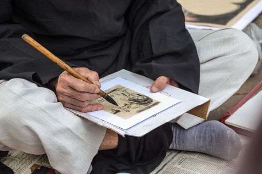 Close-up of traditional Asian calligraphy being created with a brush pen, showcasing cultural artistry.