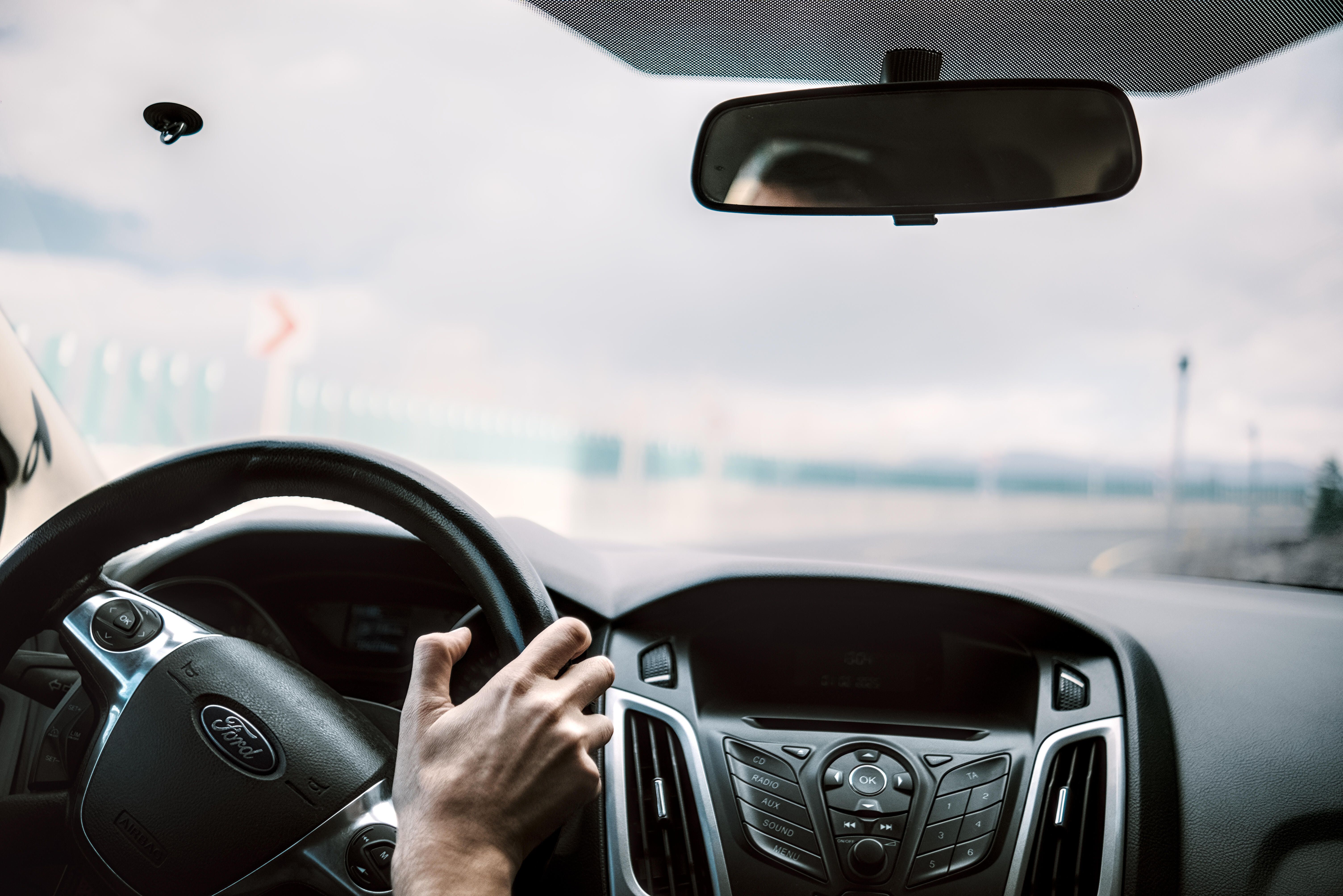 View from the driver seat showing steering wheel and rear mirror