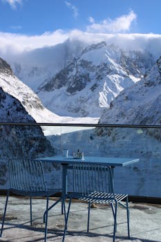 Blue table and chairs with a stunning snowy mountain backdrop.