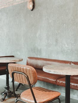 Stylish restaurant interior with leather seating and wooden tables, offering a modern industrial vibe.