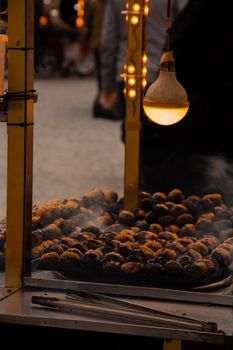 A street vendor roasting chestnuts under a warm lamp, creating a cozy atmosphere.
