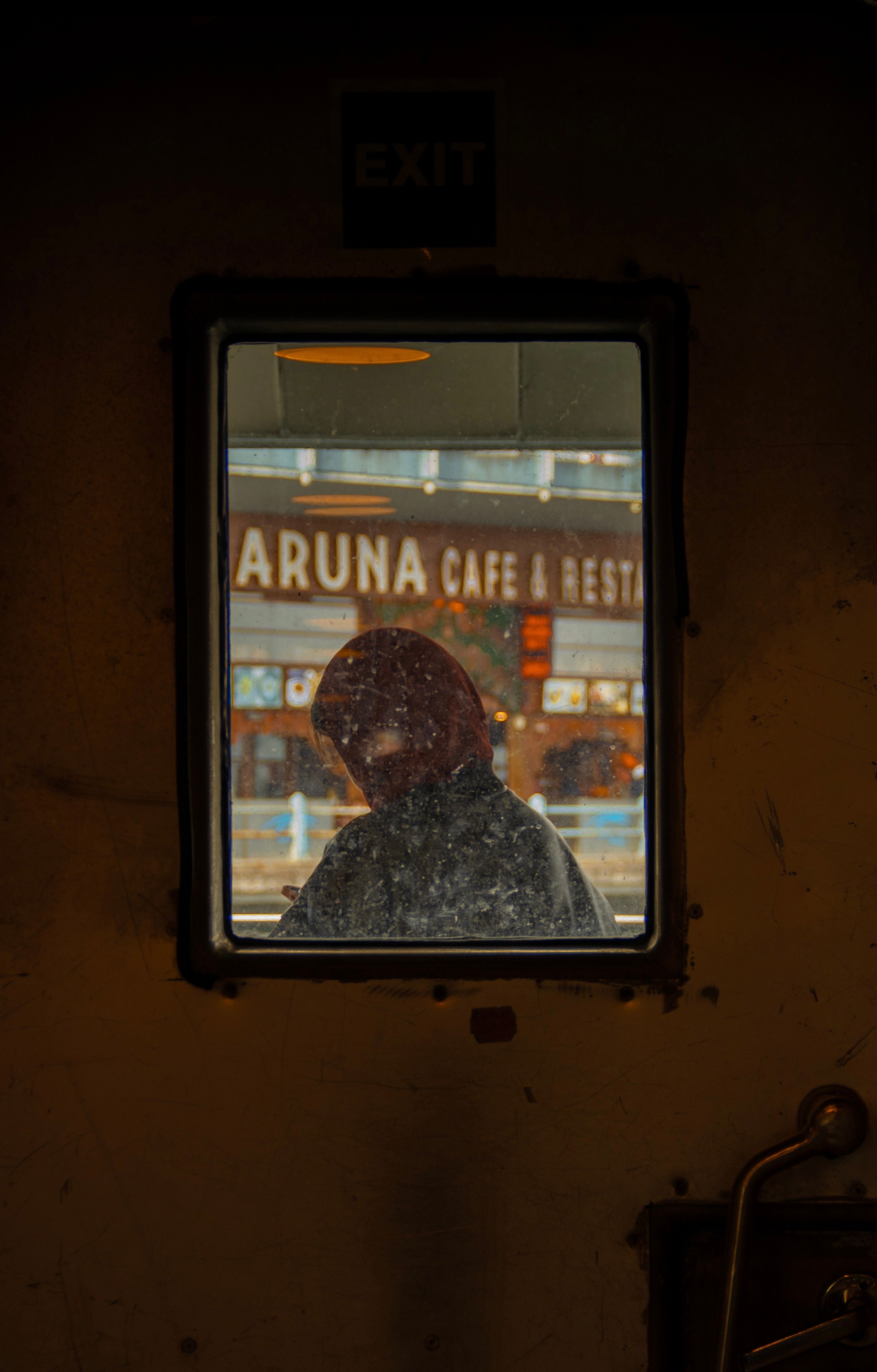 Silhouette of a person seen through a dirty window with a café backdrop in Istanbul.