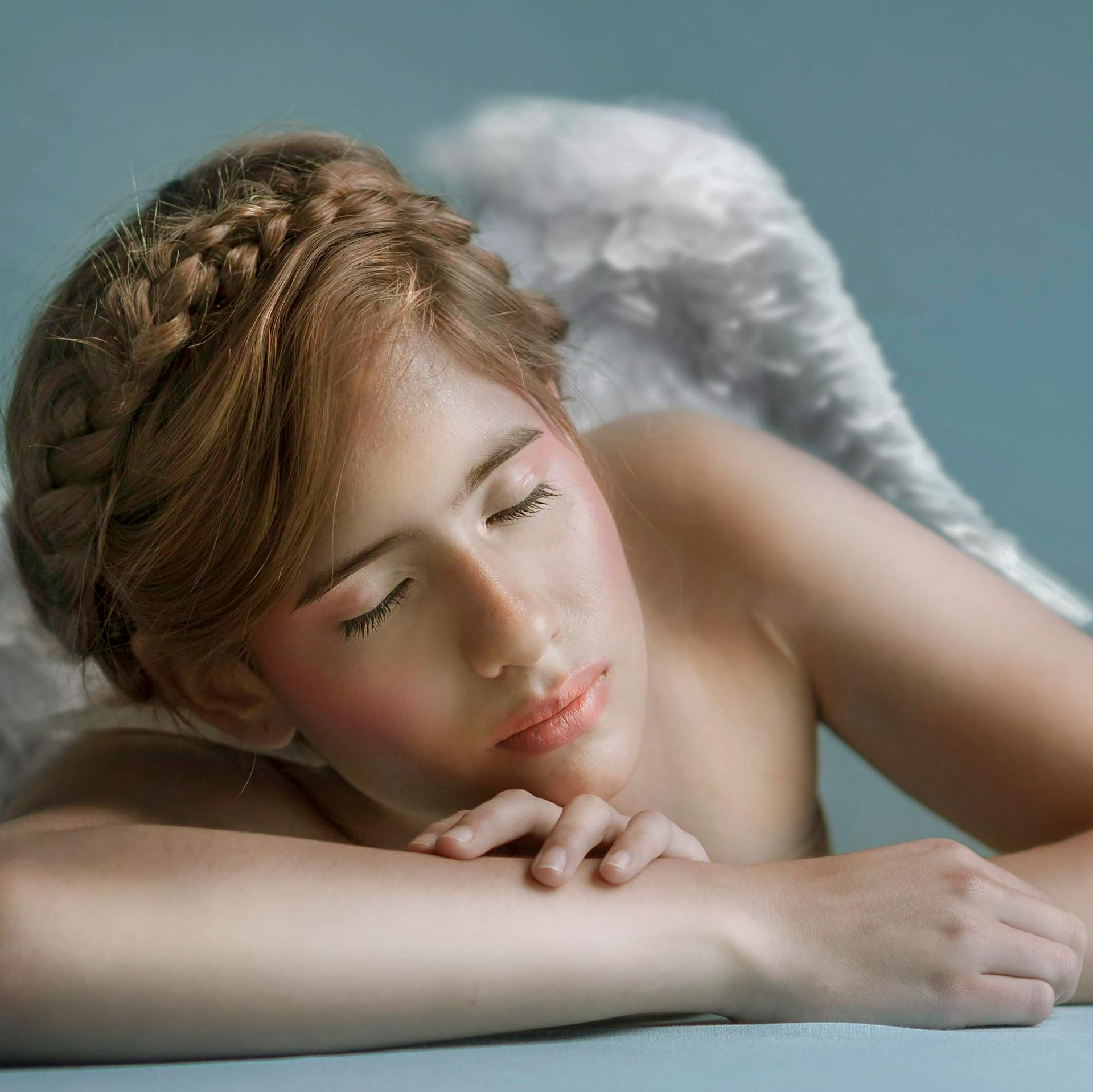 A serene portrait of a young woman with angelic wings, evoking tranquility.