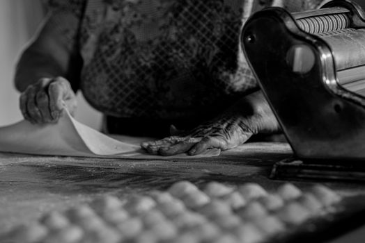 Handcrafting pasta dough with a vintage machine in a rustic kitchen setting.