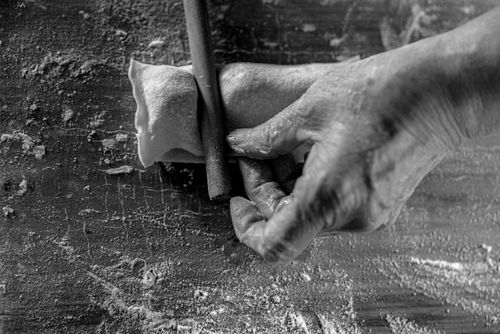Free Monochrome image of hands rolling dough with a pin on a flour-dusted surface. Stock Photo