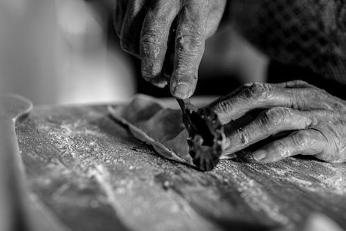 Free Black and white close-up of hands skillfully crafting homemade pasta. Stock Photo