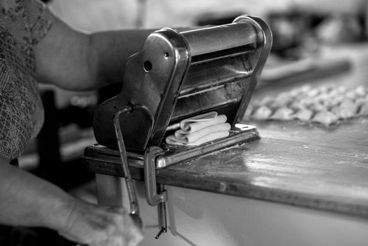 Close-up of homemade pasta being prepared with a classic pasta machine.