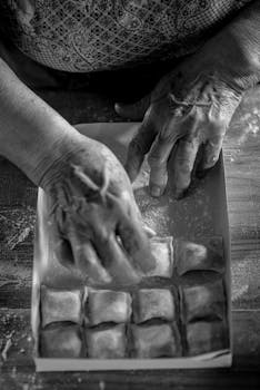 Close-up of aged hands preparing homemade pasta with care.