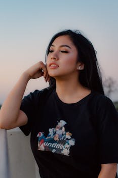 一名年轻女子若有所思地摆出姿势，背景是柔软的天空