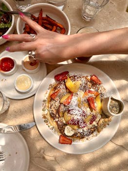 Tasty brunch plate featuring pancakes topped with fresh fruit and syrup in a sunlit Los Angeles cafe.