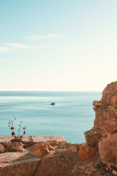 Free A tranquil view of the sea from Gelibolu, Turkey with a boat on the horizon. Stock Photo