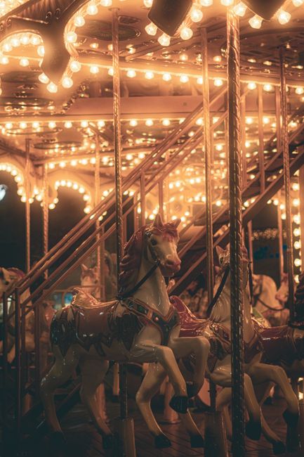 An enchanting night view of a vintage carousel with brightly lit horses and warm lights.