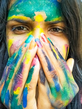 镜头特写一位年轻女子，她面容鲜艳，手绘颜料，展现了创造力