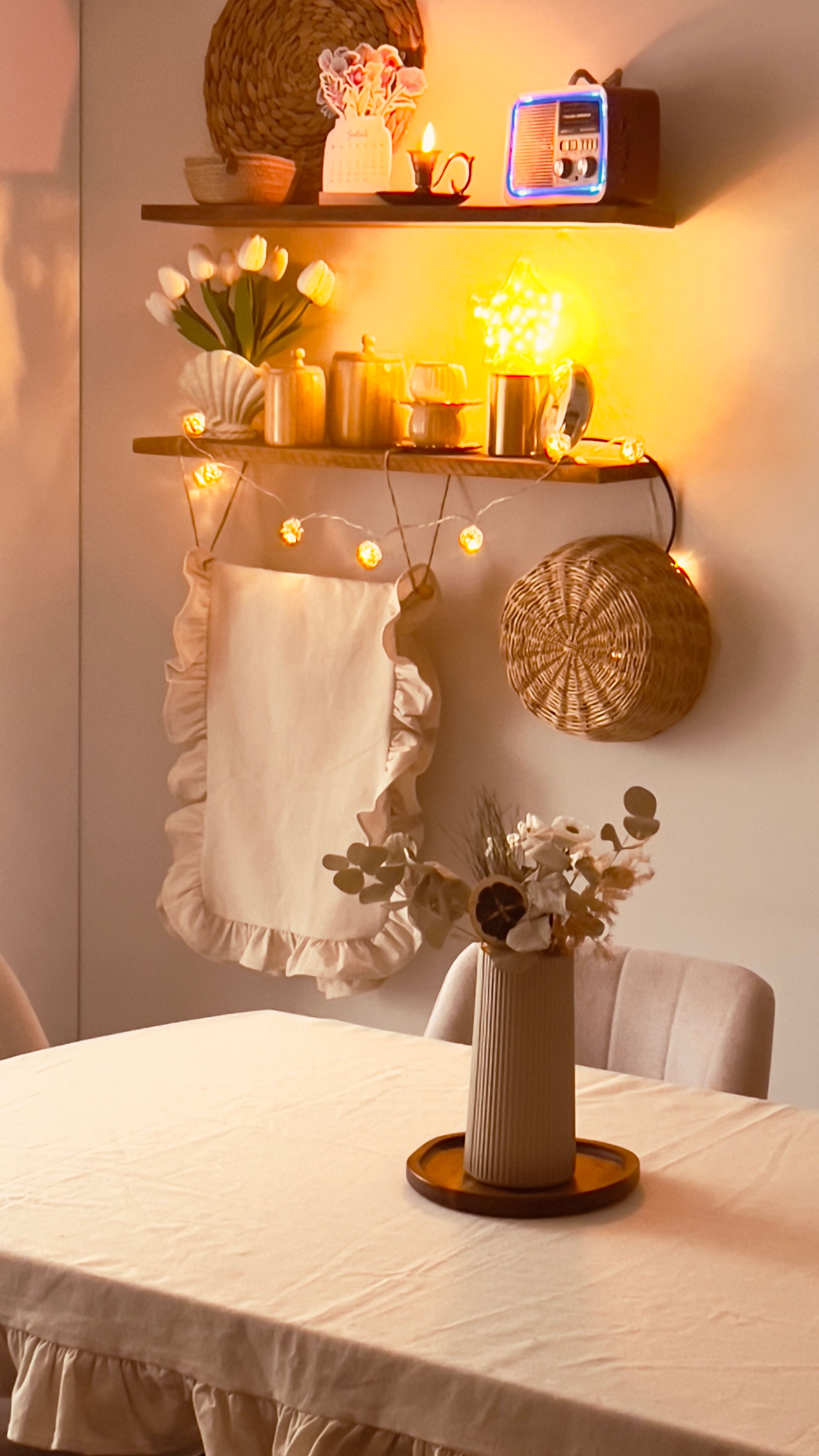 A cozy dining area with warm lighting, flowers, and rustic decor.