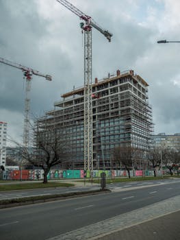 Dynamic high-rise building under construction with cranes in Wrocław, Poland.