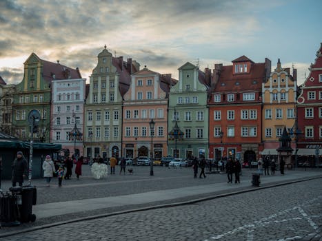 Charming colorful townhouses in Wrocław's historic Market Square during a cloudy day.