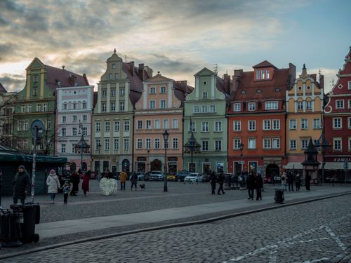 Free Charming colorful townhouses in Wrocław's historic Market Square during a cloudy day. Stock Photo