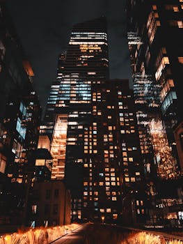 Spectacular night view of illuminated skyscrapers in a bustling city, reflecting the urban nightlife.