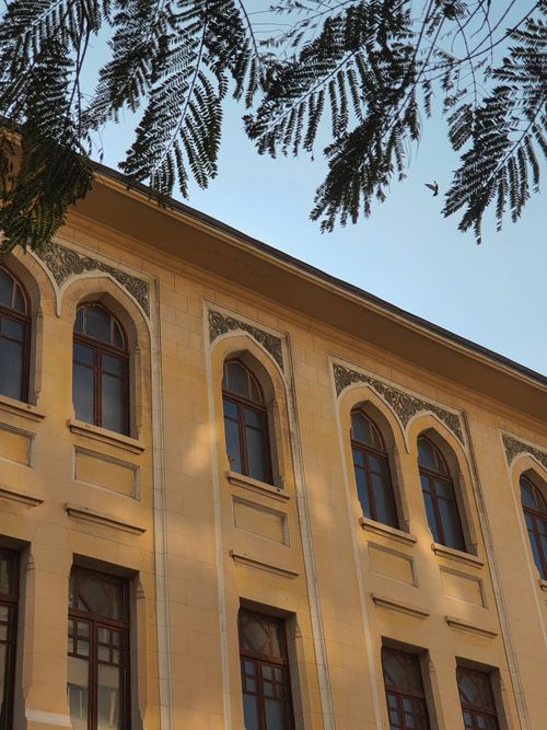 Free Elegant historical building facade with decorative arches and clear sky. Stock Photo