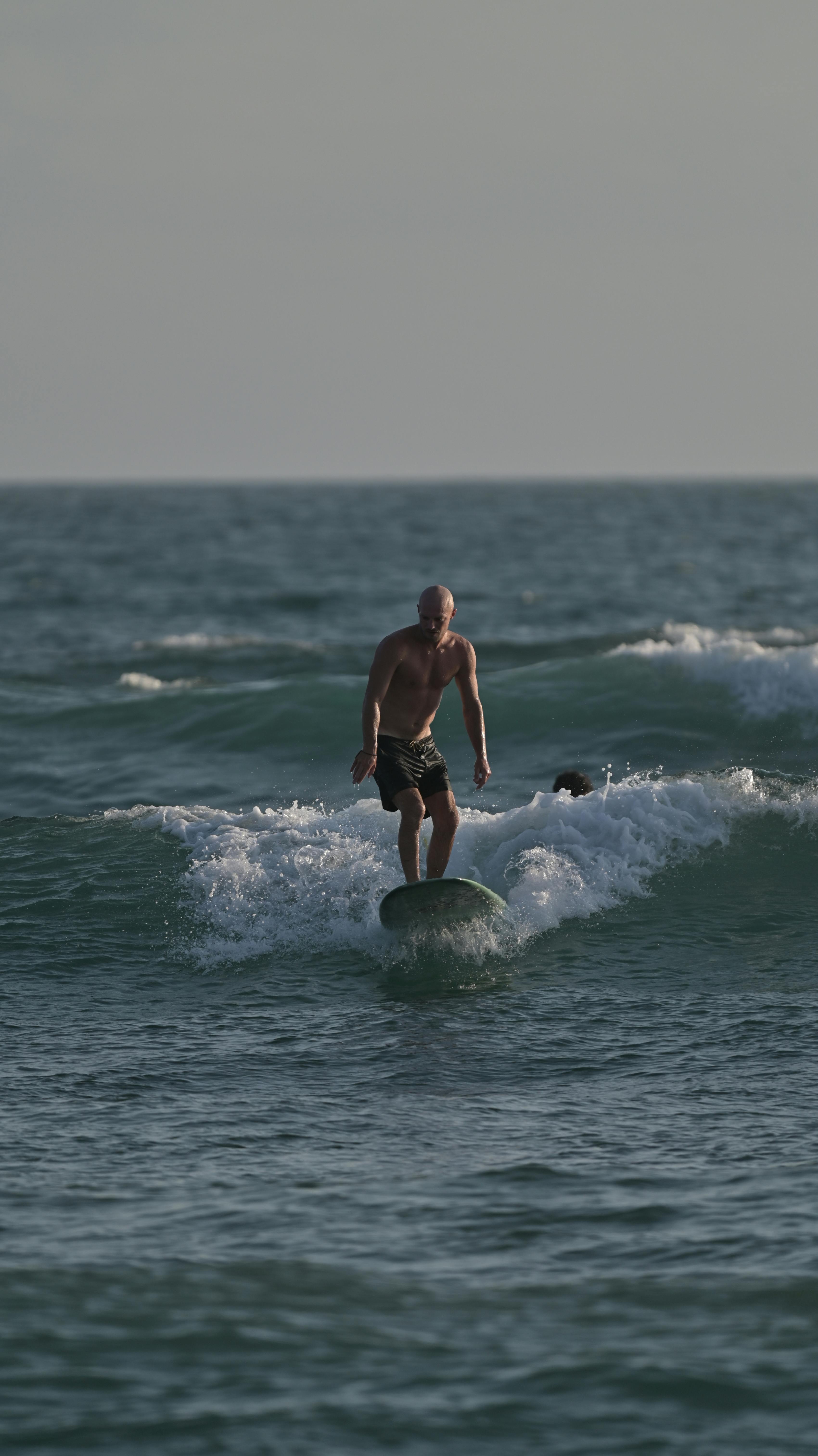 A surfer rides the waves in Bali, Indonesia, capturing the thrill of adventure sports.