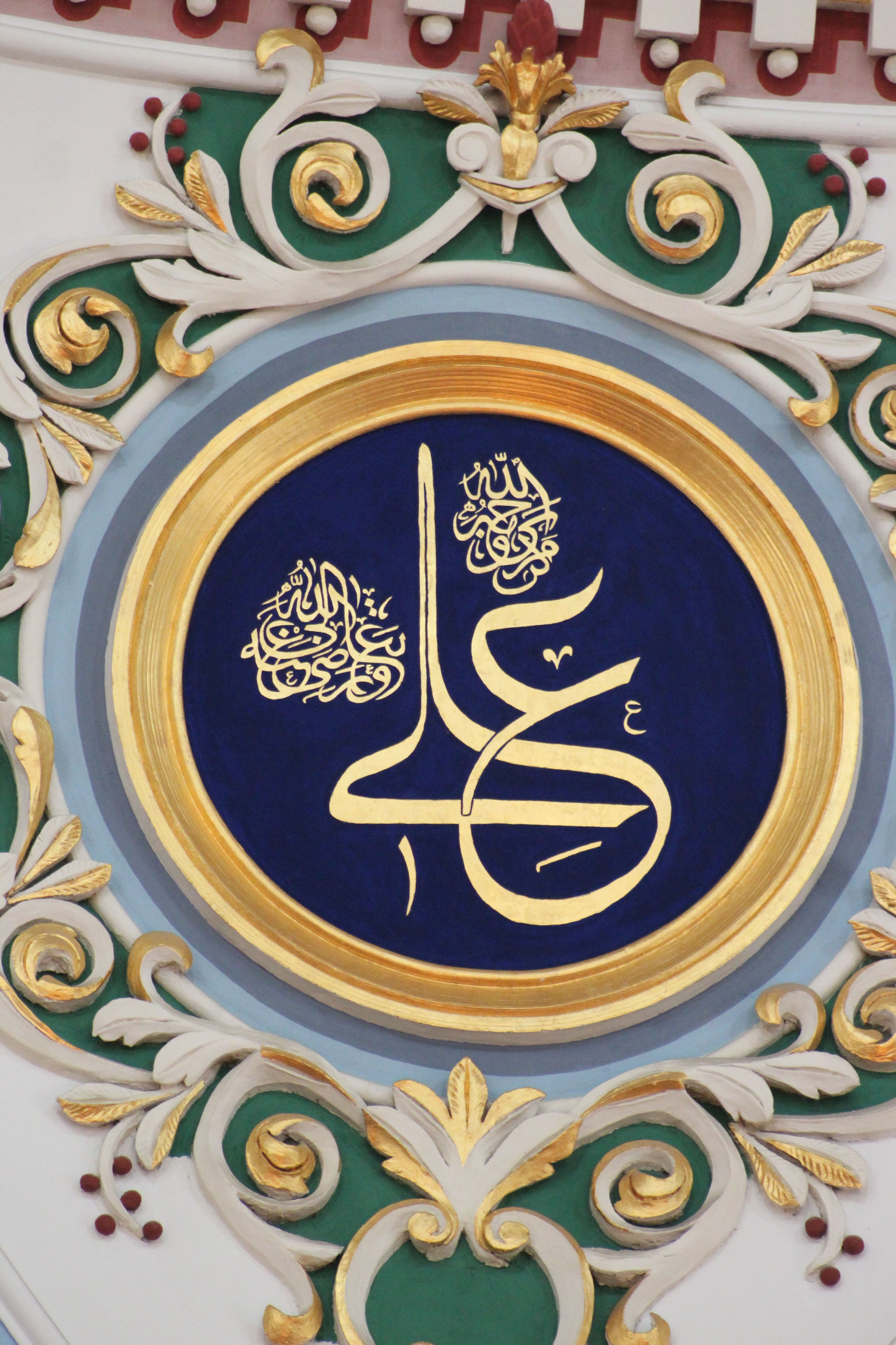 Intricate Islamic calligraphy artwork with ornate floral decorations.