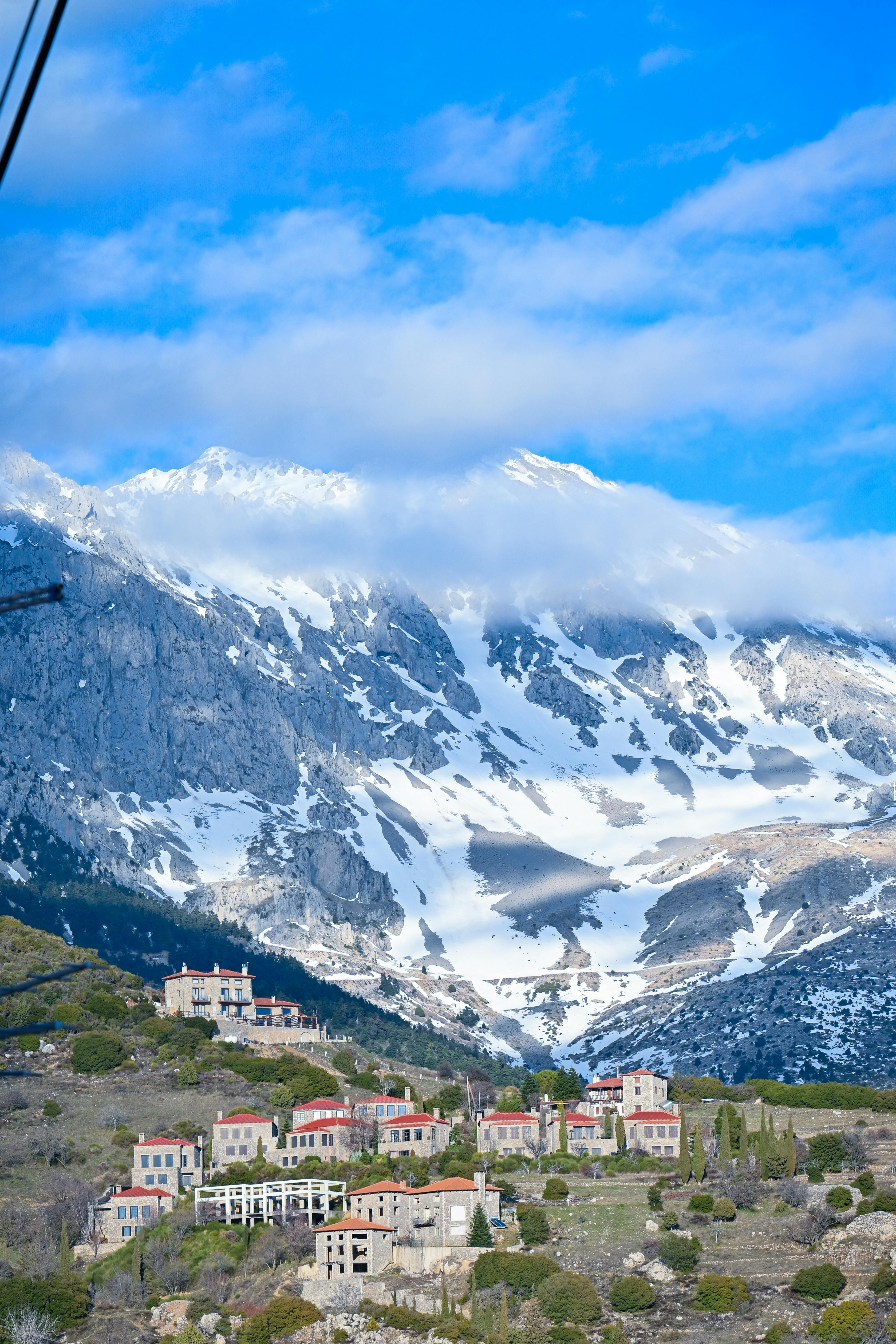 Picturesque Arachova town nestled in snowy Greek mountains under a bright blue sky.